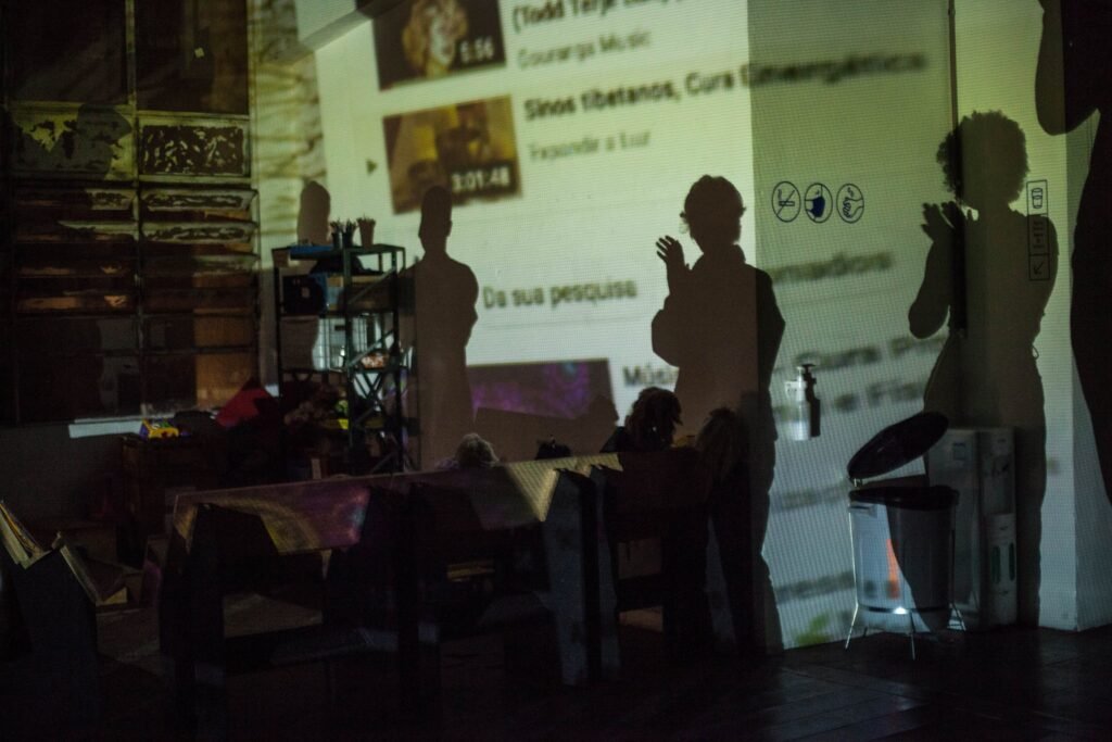 Sombras de pessoas aplaudindo sobre a projeção, na Casa do Povo