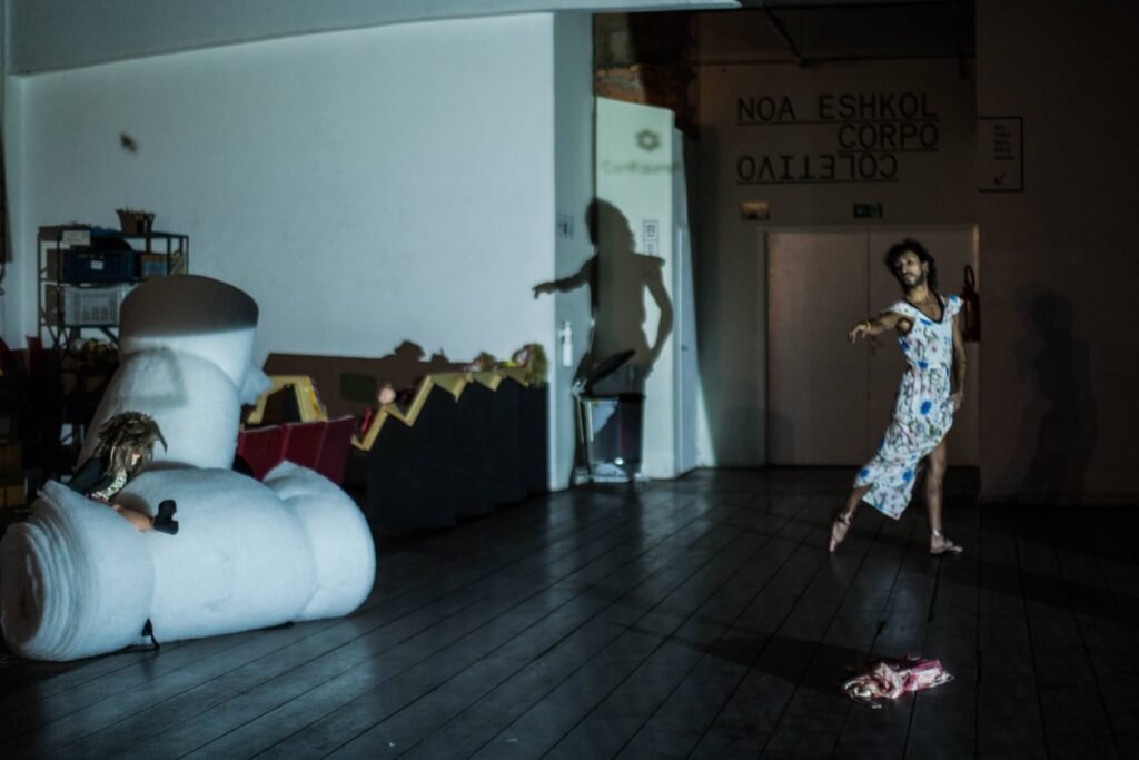 Performer de vestido estampado dança na Casa do Povo, entre esculturas infláveis brancas