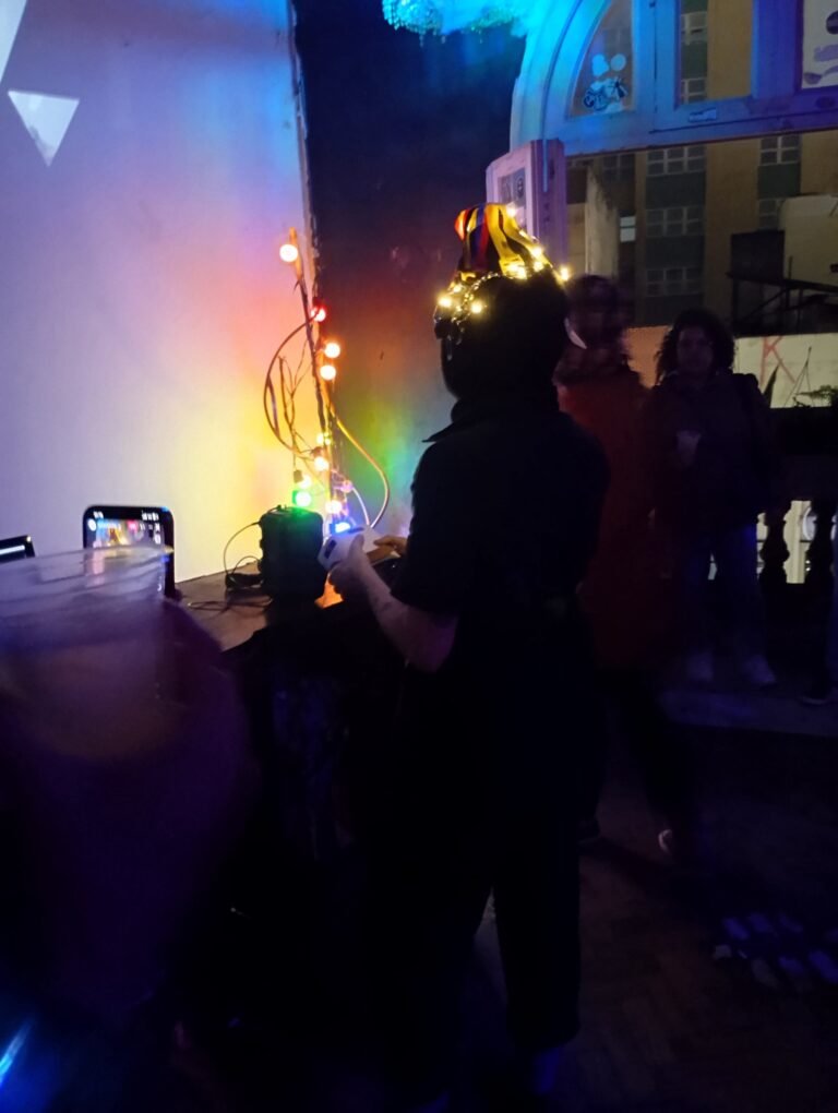 Integrante da Boleia Coletiva com luzes na cabeça diante de uma bancada iluminada