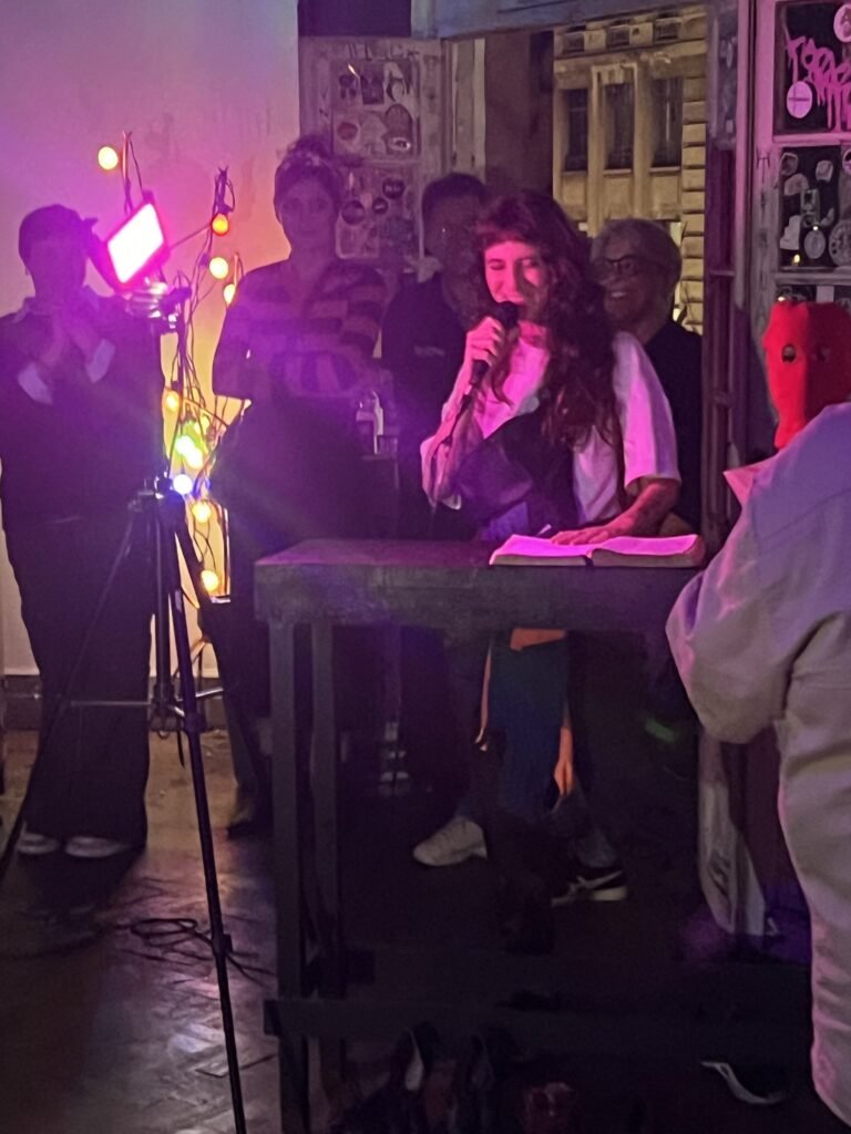 Integrante da Boleia Coletiva lê ao microfone diante de um púlpito