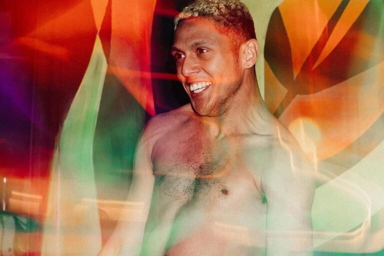 Jon Diegues sorri em movimento, entre luzes coloridas