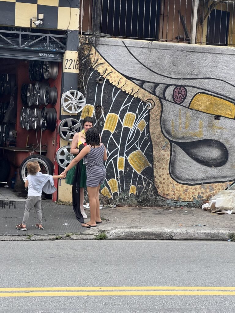 Kareen Labbé Weber diante de um muro grafitado ao lado de uma borracharia, com uma criança por perto