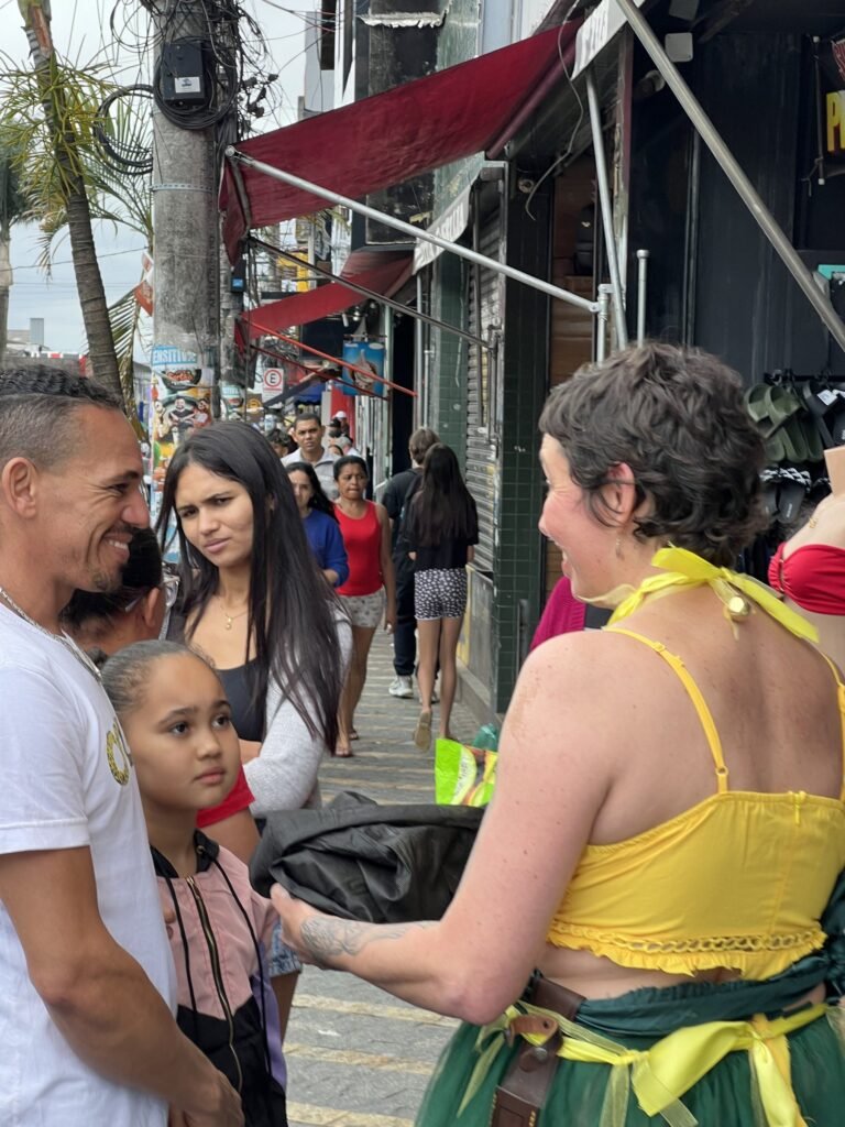 Kareen Labbé Weber conversa com uma família na calçada, entre lojas de roupa