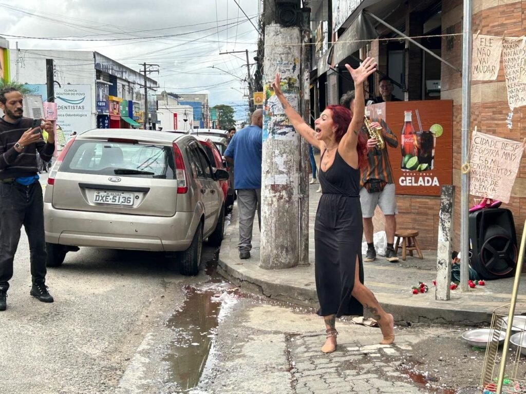 Teresa Ricco de braços erguidos na rua comercial de Heliópolis