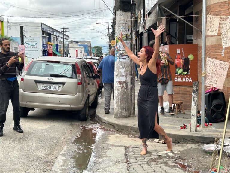Teresa Ricco de braços erguidos na rua comercial de Heliópolis