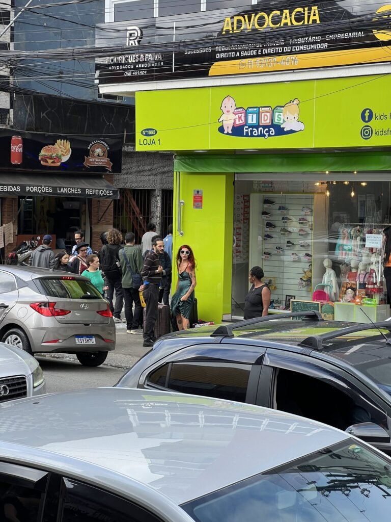 Rua comercial de Heliópolis com Teresa Ricco ao fundo, diante de uma loja verde