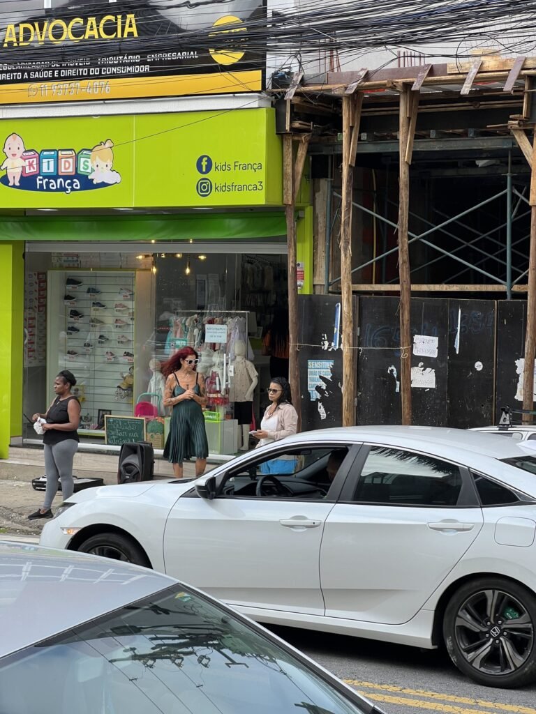 Teresa Ricco dança na calçada, vista de longe entre carros estacionados