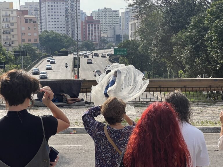 Público fotografa Thales Ferreira com o plástico erguido pelo vento sobre a avenida