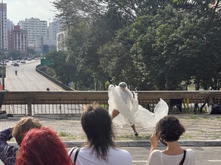 Thales Ferreira caminha com o plástico junto à mureta, observado pelo público