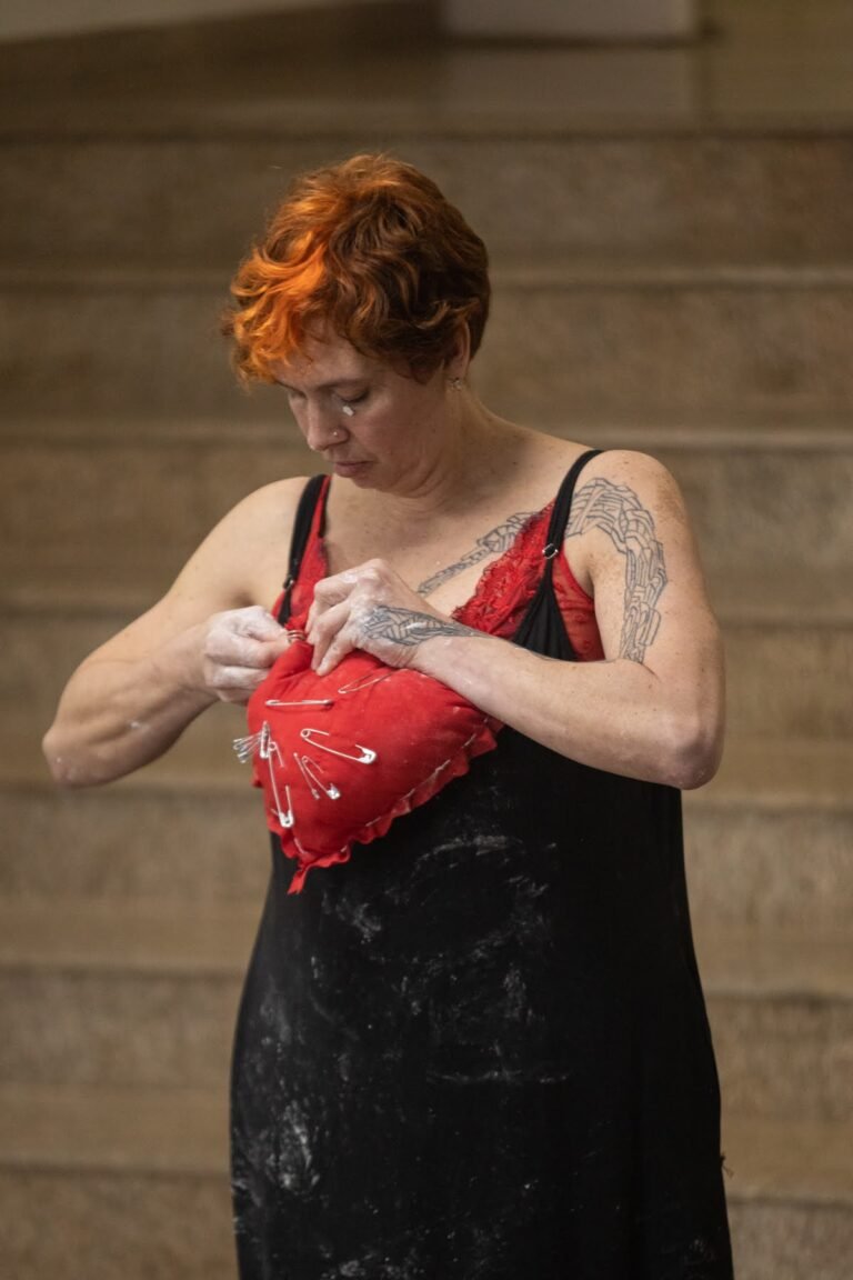 Kareen Labbé Weber prende ao peito, sobre o vestido preto, um coração de tecido vermelho