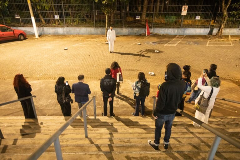 Vista do alto da escadaria: o público observa PC ao longe, no meio da praça