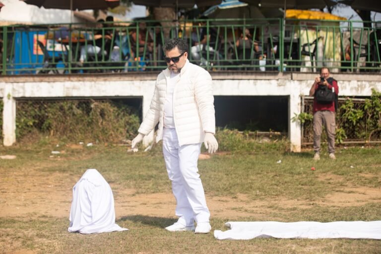 Pio Santana, de luvas brancas, diante de um volume coberto com tecido branco no gramado