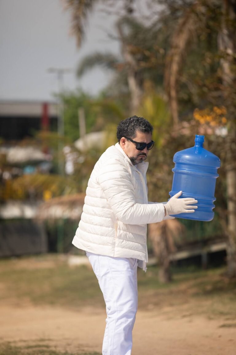 Pio Santana carrega o galão azul junto ao corpo